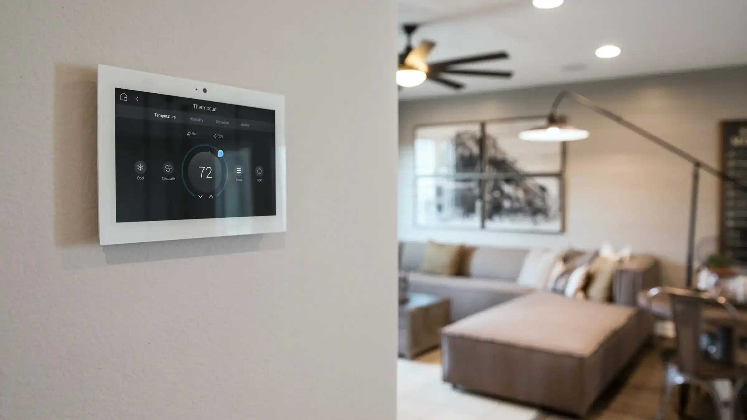 Modern smart thermostat mounted on a wall in a stylish living room.