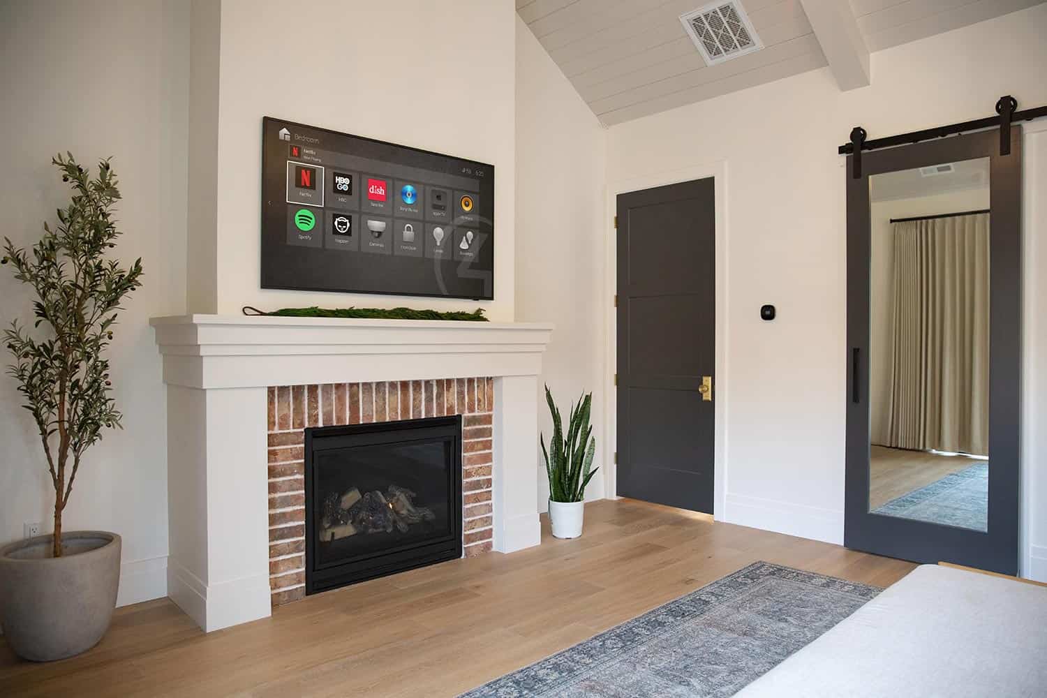 Living room featuring a fireplace, wall-mounted television, and a sliding barn door with mirror
