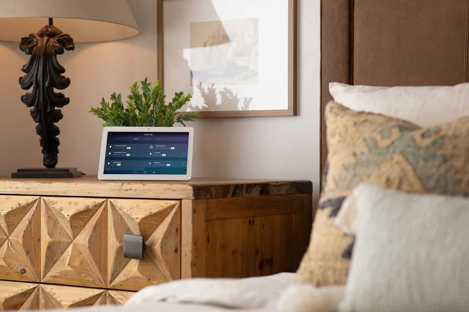 Digital tablet displaying home automation settings on a rustic wooden nightstand