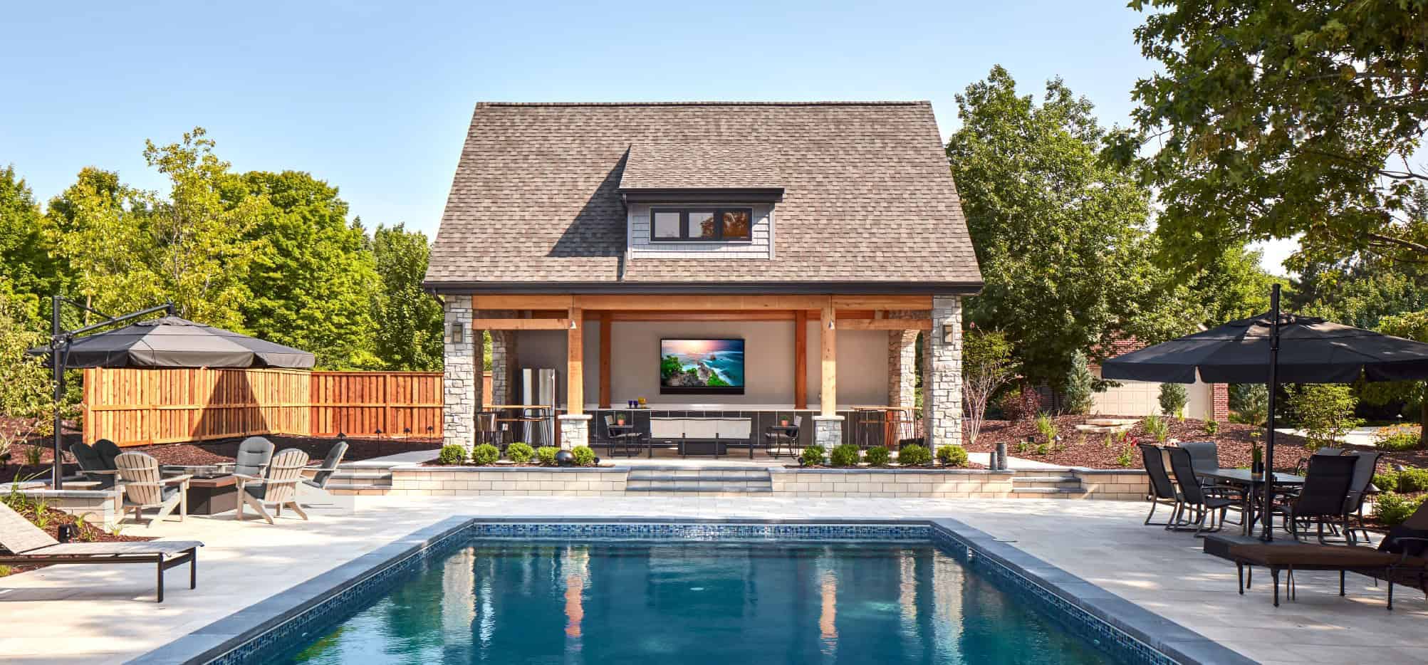 Elegant backyard with pool, outdoor seating, and shaded lounge areas.