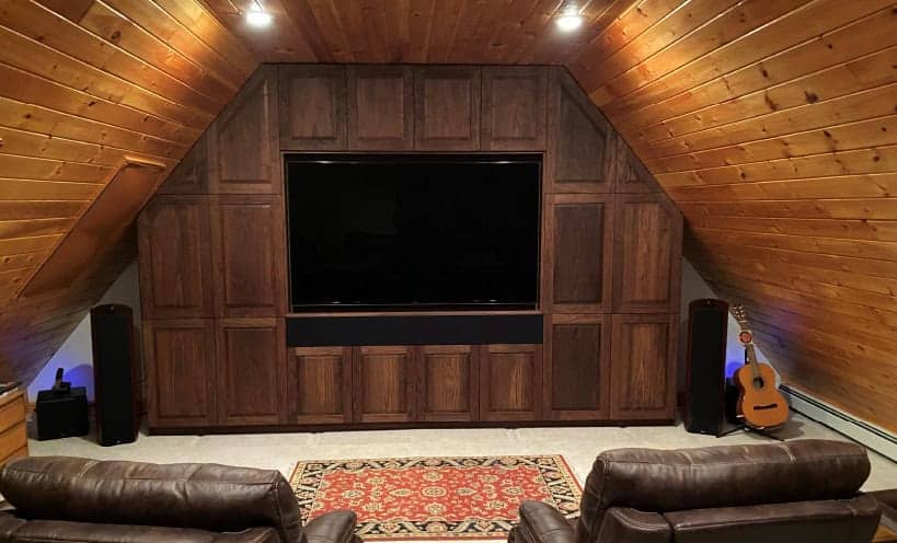 Home theater with large TV, surround sound speakers, and cozy seating.