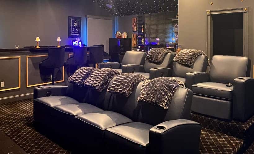 Comfortable black leather theater seats with plush blankets in a modern home theater.